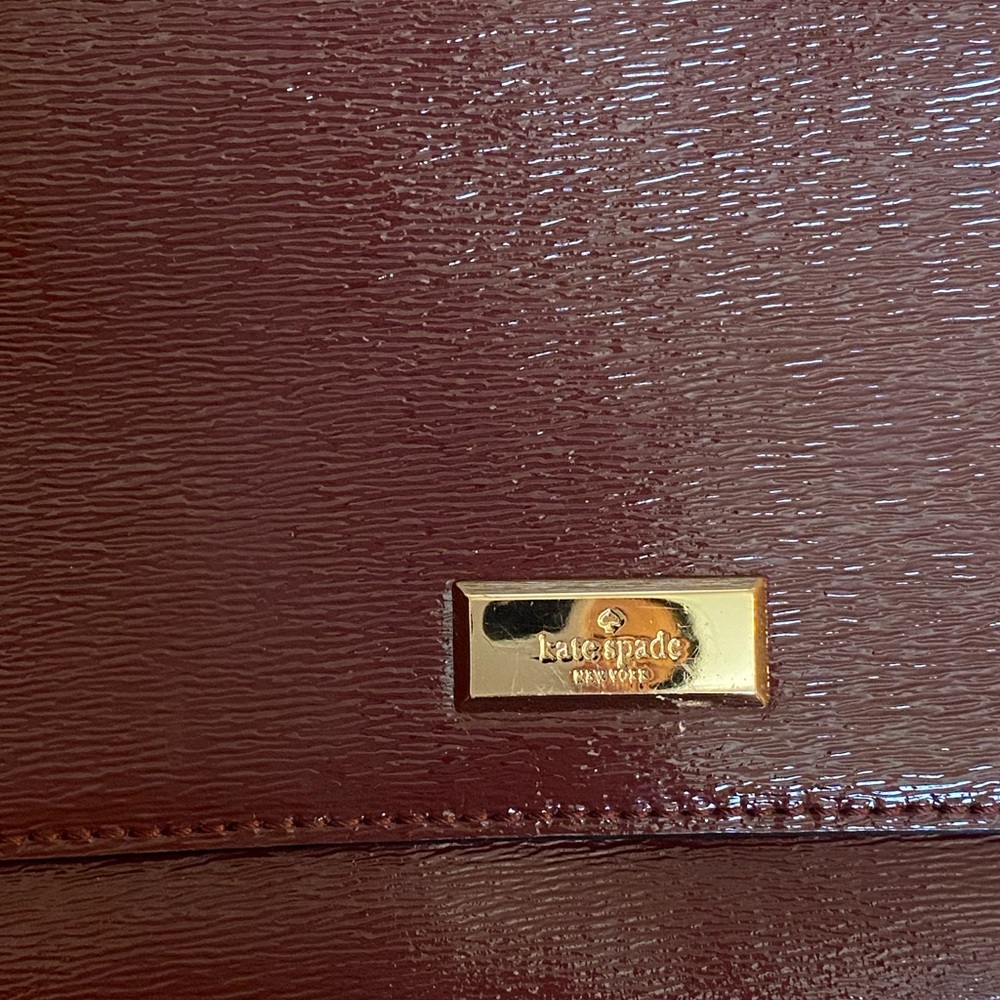 Crossbody patent leather purse. It’s maroon, some photos make it look darker